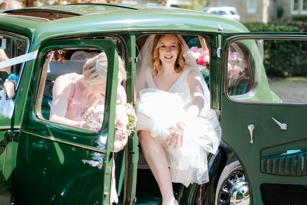 Bride arriving at her Old Milverton Church wedding in green wedding car