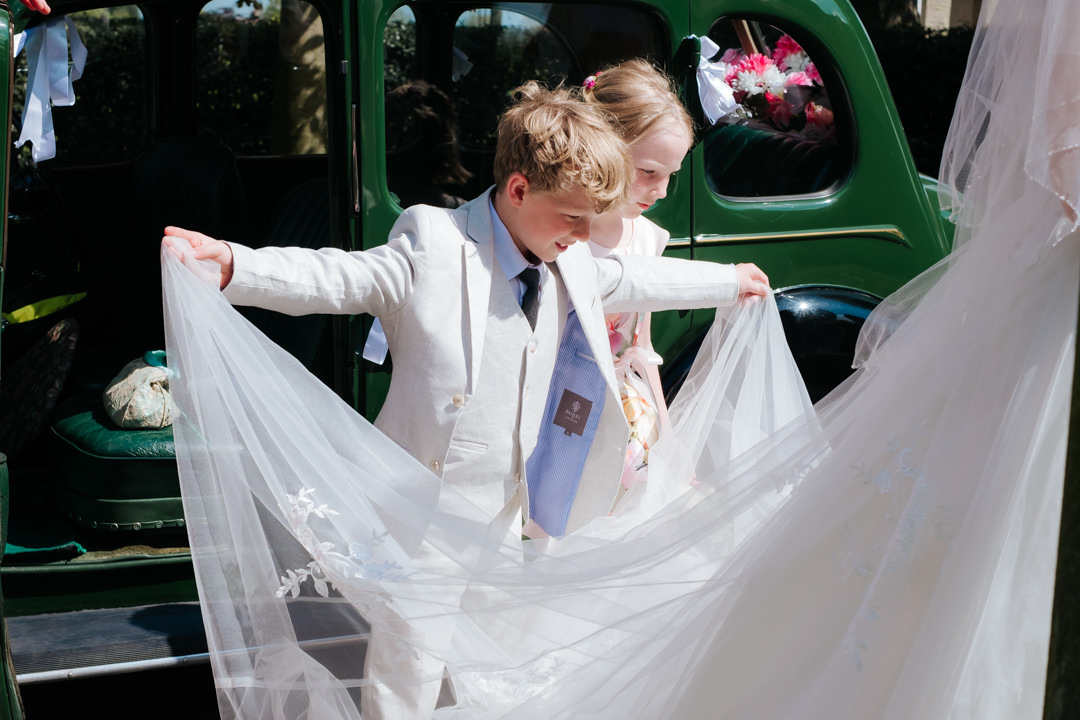 Page Boy holding brides wedding veil at Old Milverton Church wedding