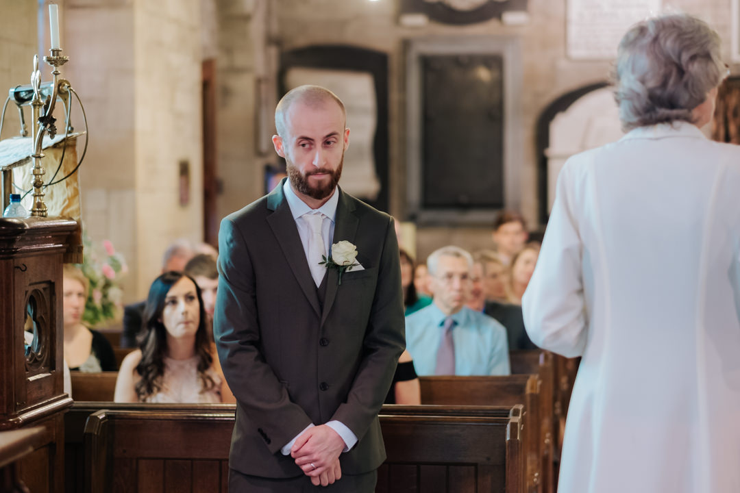 Groom waiting for his bride in Old Milverton Church on their wedding day, before heading to the Saxon Mill for their wedding reception