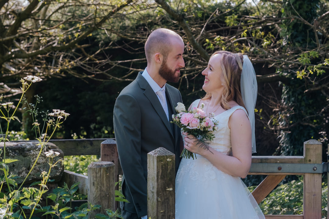 Bride and groom looking into eachother's eyes over style at saxon Mill wedding