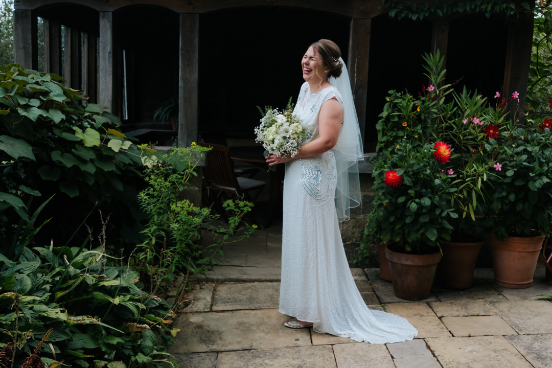 Fun bride laughs whilst being photographed at Gravetye Manor prior to getting married at Nymans Gardens