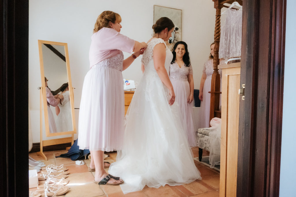 Bride getting into her wedding dress at Worton Hall wedding venue