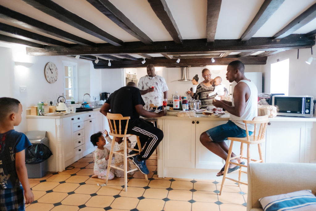African family enjoy breakfast together in the old farmhouse at worton hall prior to their Fusion wedding in the garden