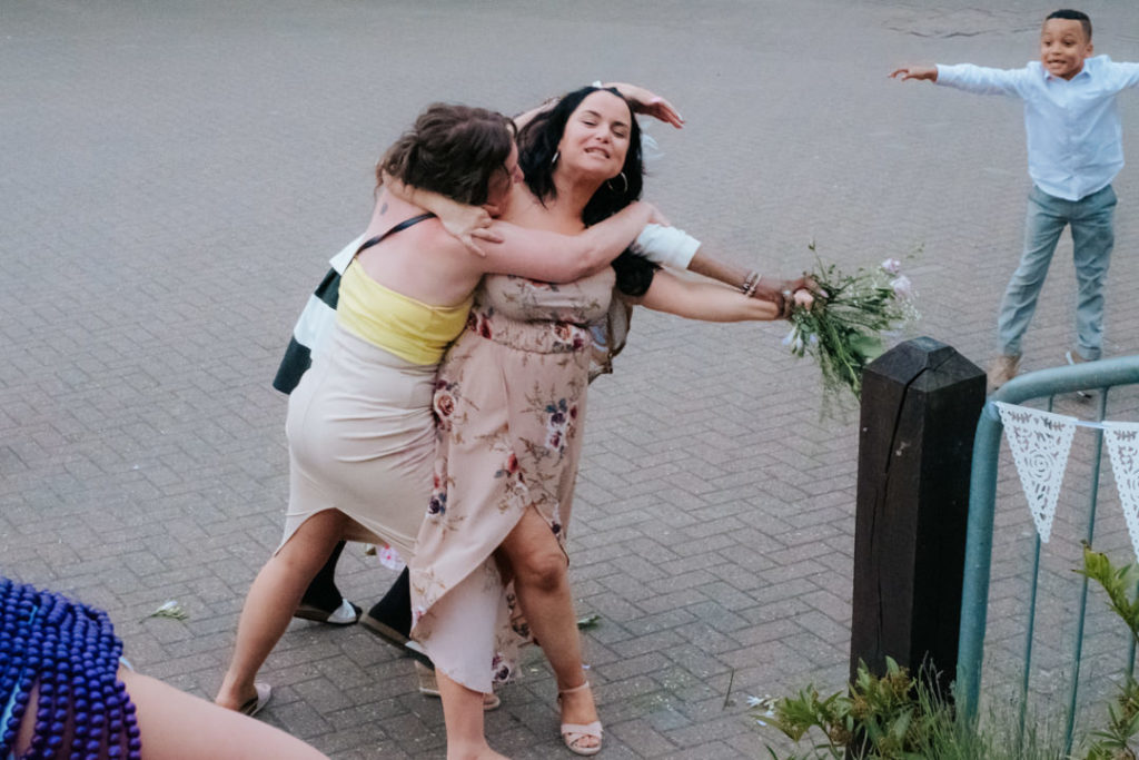 2 female wedding guests fight over the wedding bouquet at Worton Hall wedding venue
