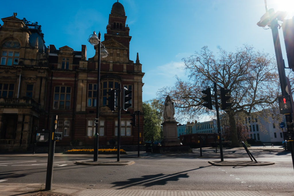 Leamington spa town hall with statue of Queen Victoria standing proud against a bright sunny blue sky. photographed during Corona Virus lockdown period so the roads are empty