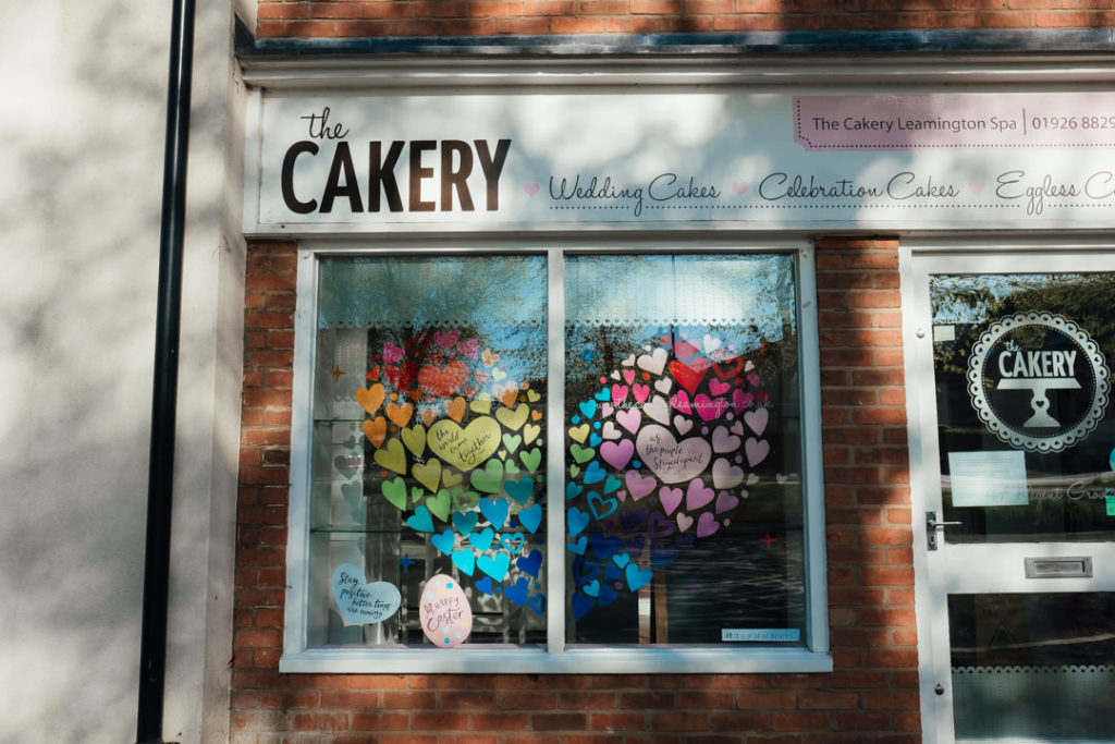 Leamington Spa Holly walk showing the Cakery's bright heart shaped rainbow window display. Photographed during Corona Virus lockdown period so the roads are empty