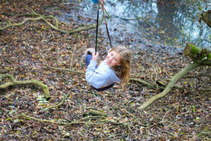 Teenage girl smiling whilst on a rope swing