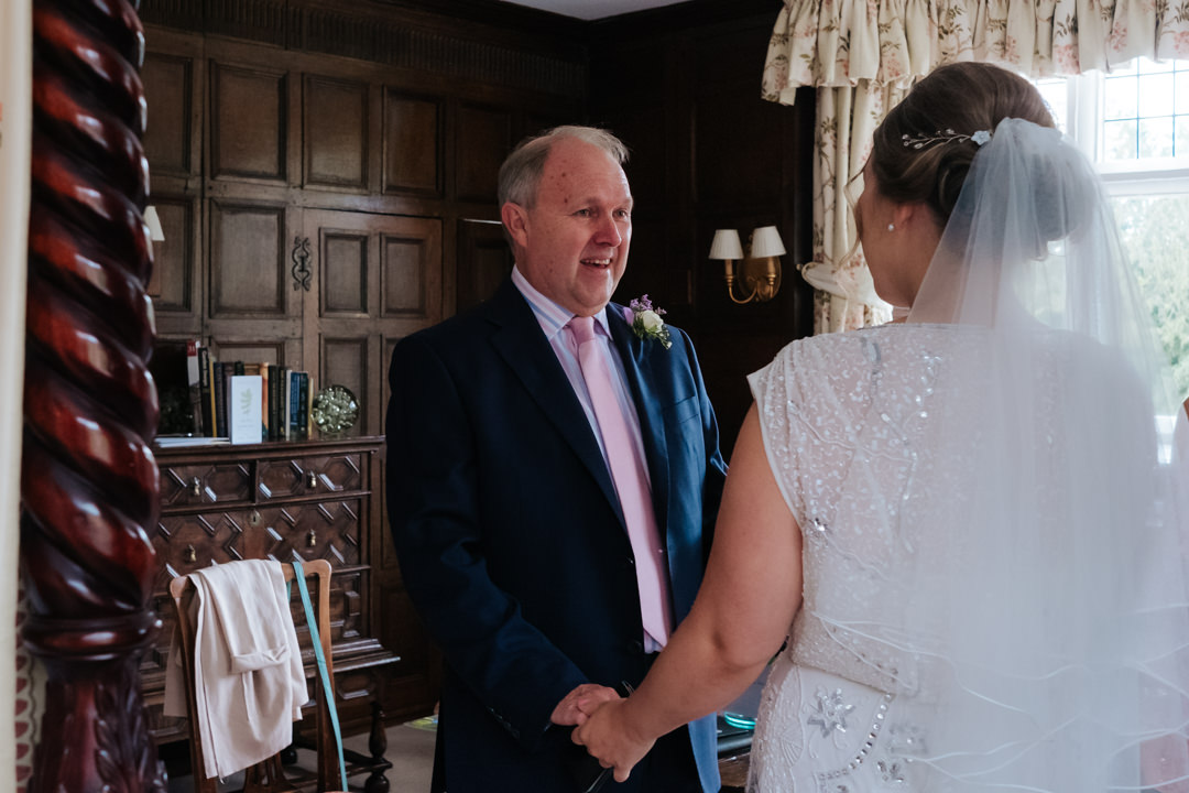 Father of the bride see's his daughter for the first time as she is ready to get married at Gravetye Manor wedding venue