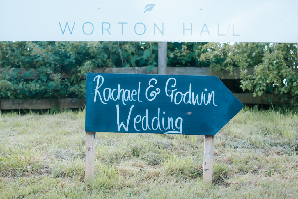 chalkboard sign reading Rachael & Godwin wedding outside Worton Hall wedding venue