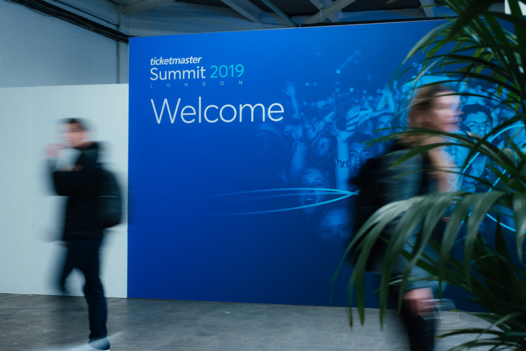 corporate event photography showing a blue sign at the entrance of ticketmaster's annual summit
